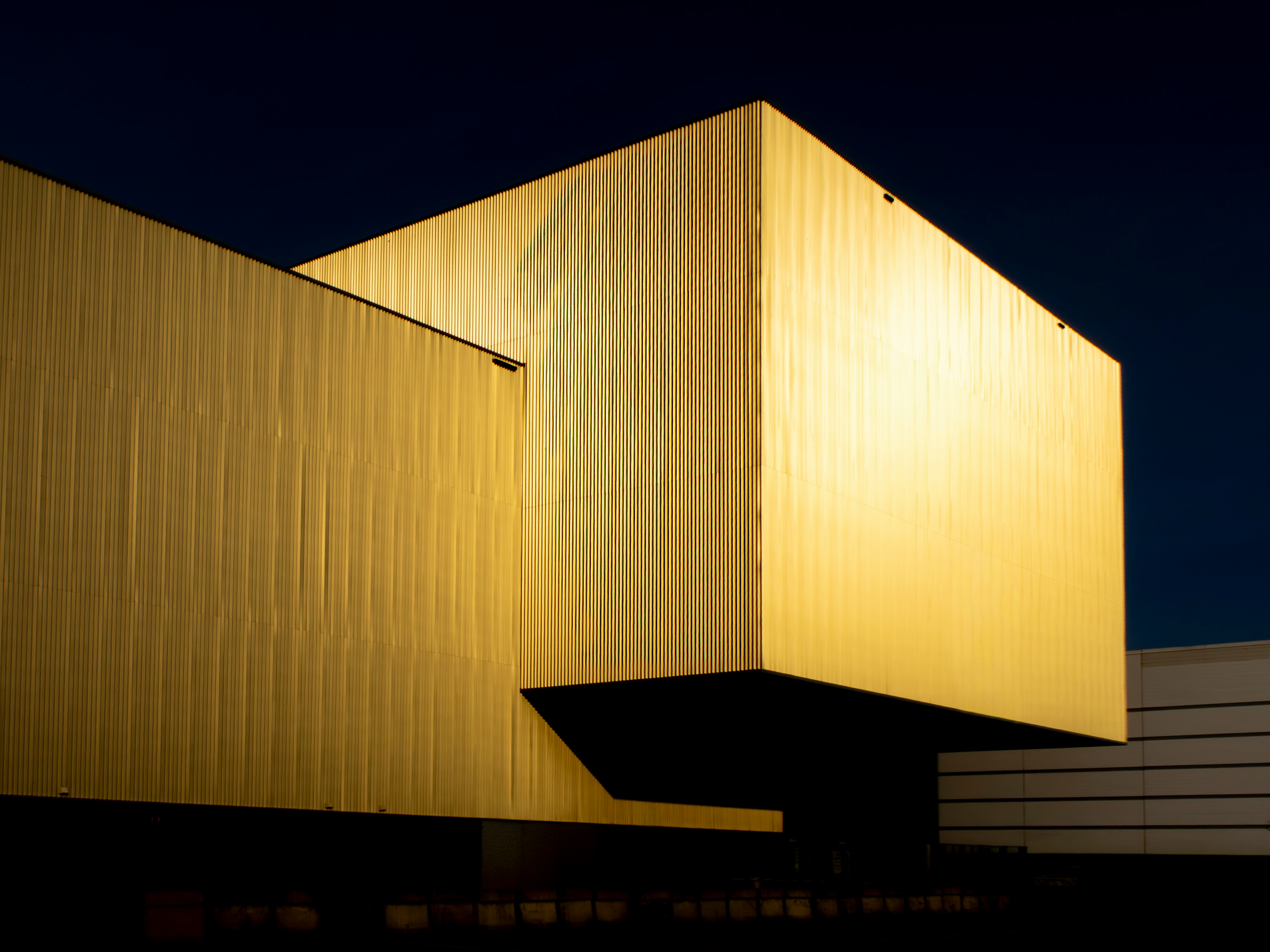 Golden modern building against a dark night sky